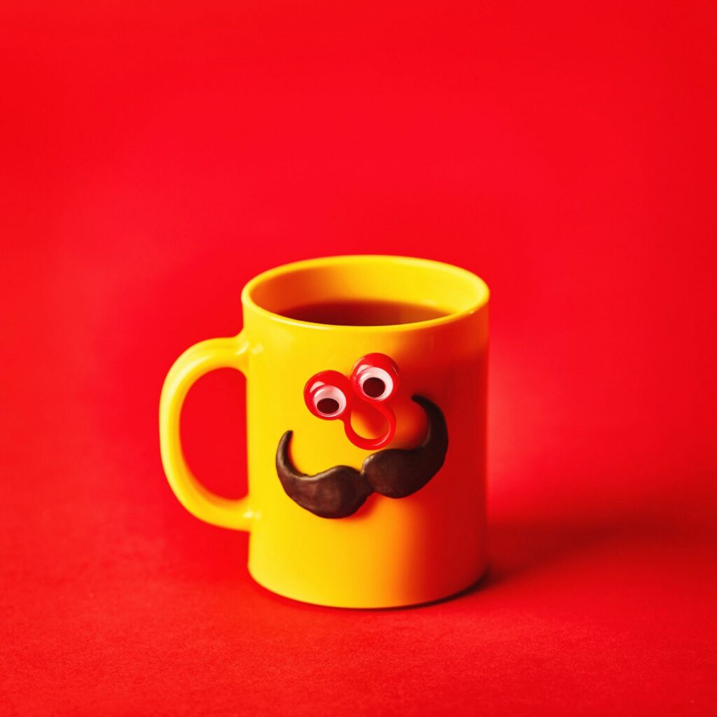 Coffee cup character with eyes and mustache on red background