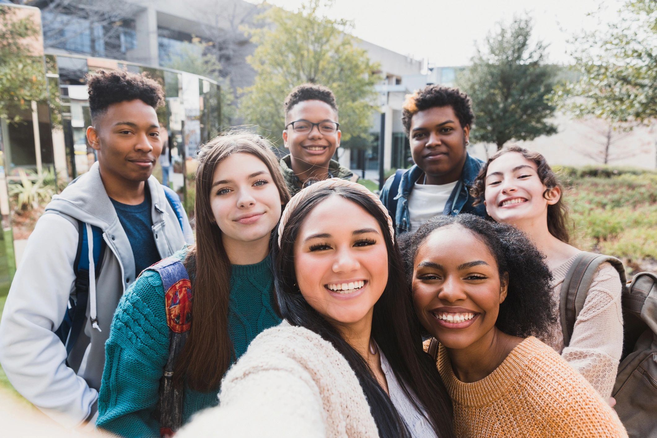Happy students smiling at the camera outdoors