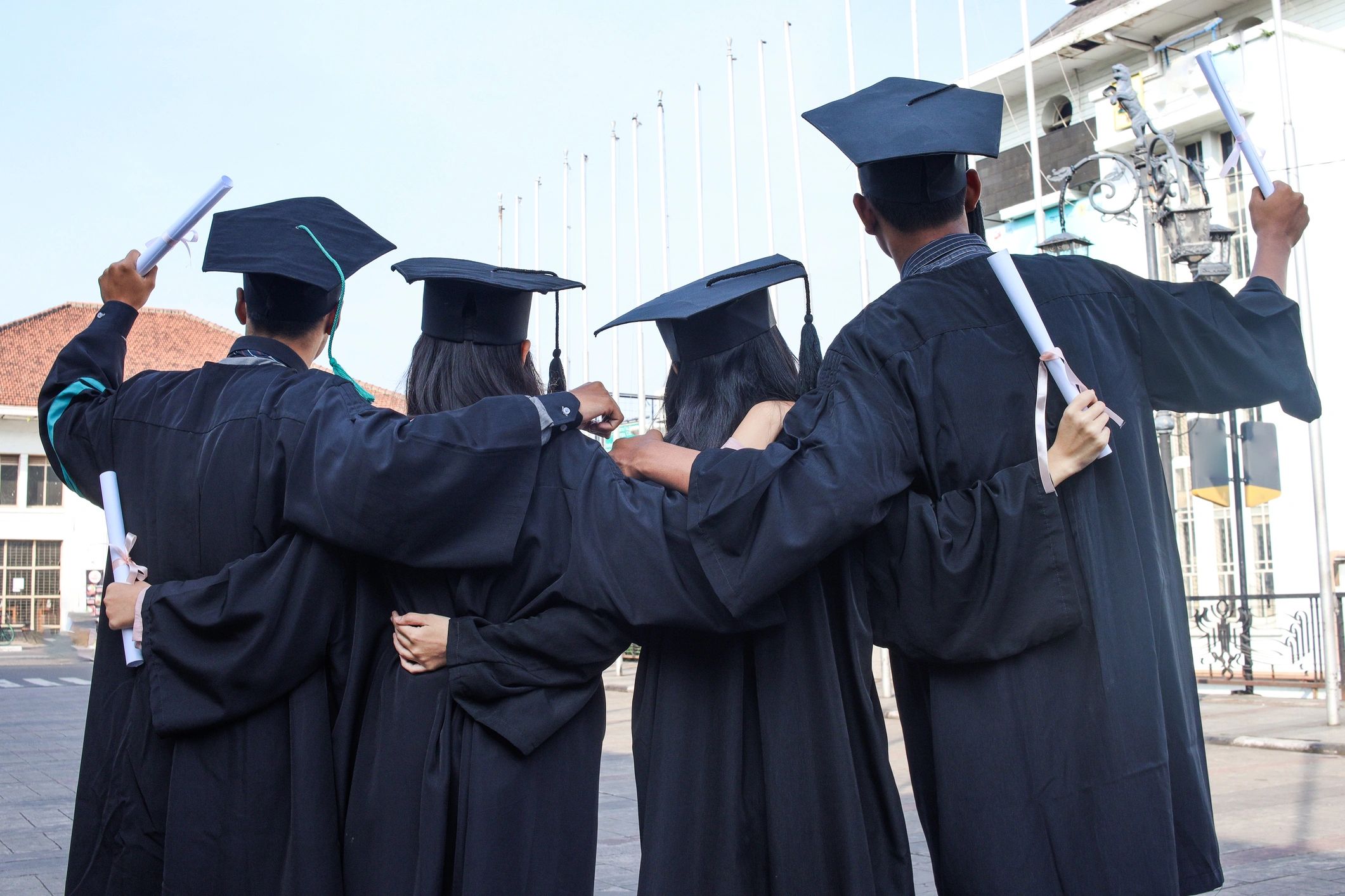 Graduates celebrating together in caps and gowns