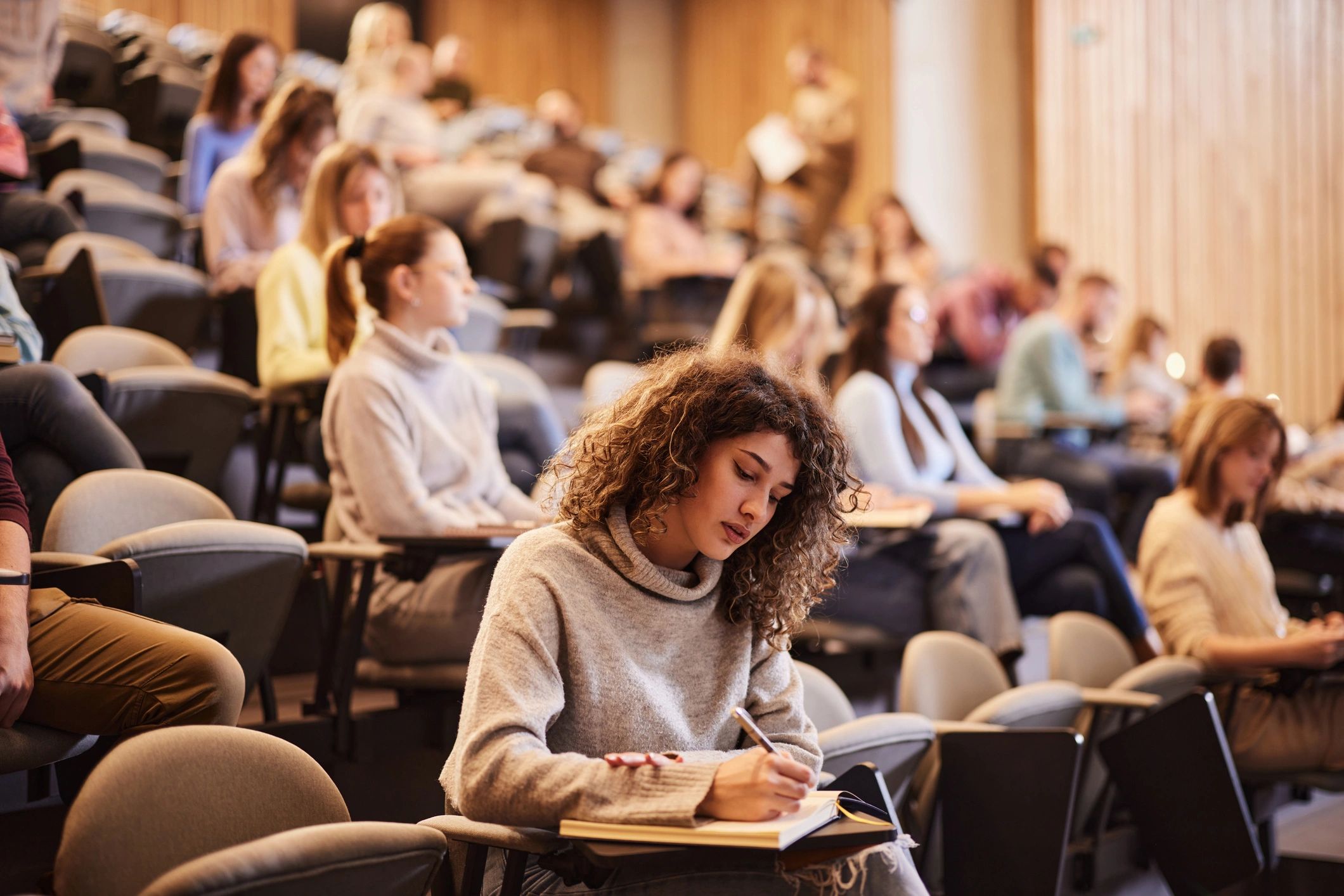 University student completing an exam in a lecture hall