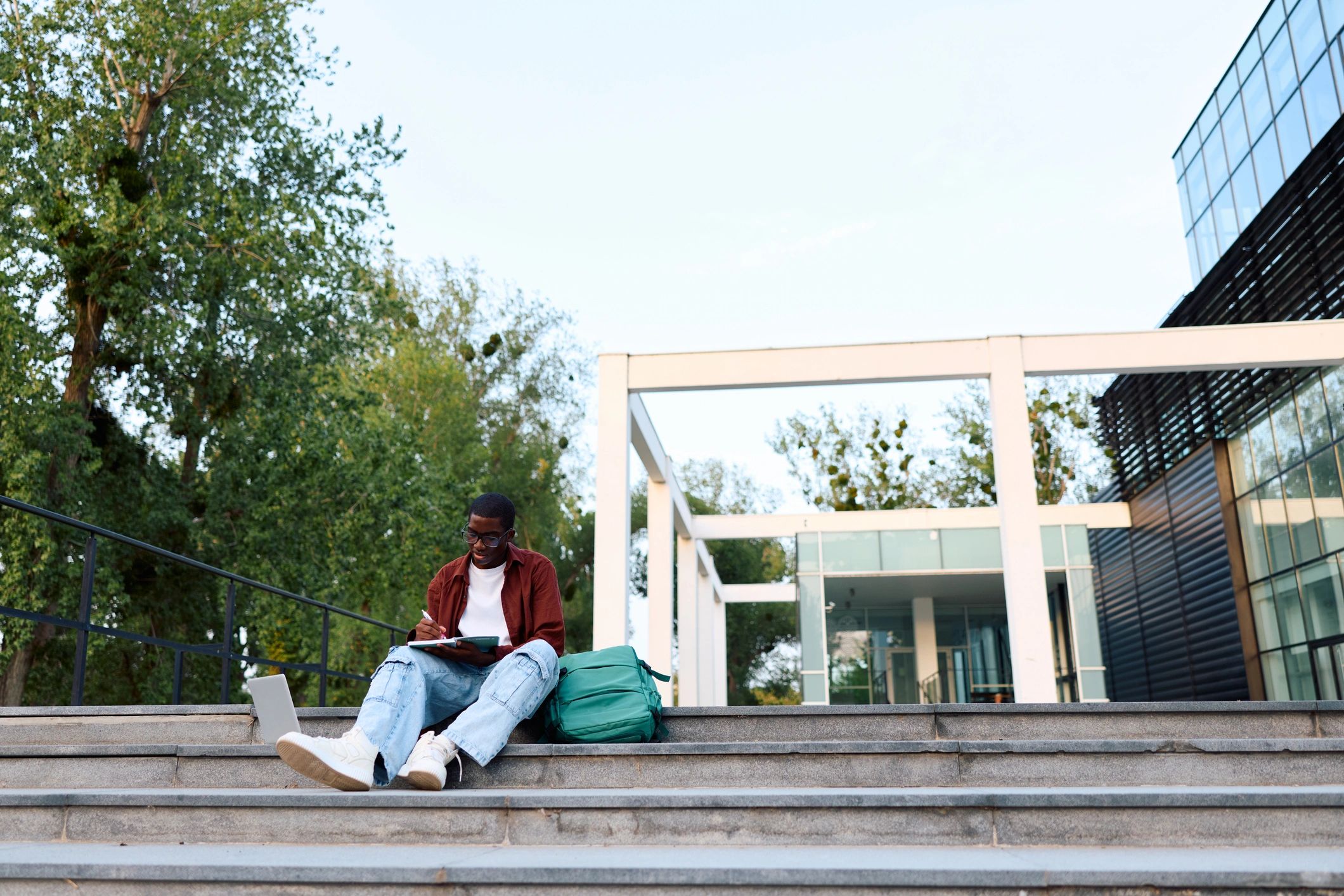 Student writing notes on campus
