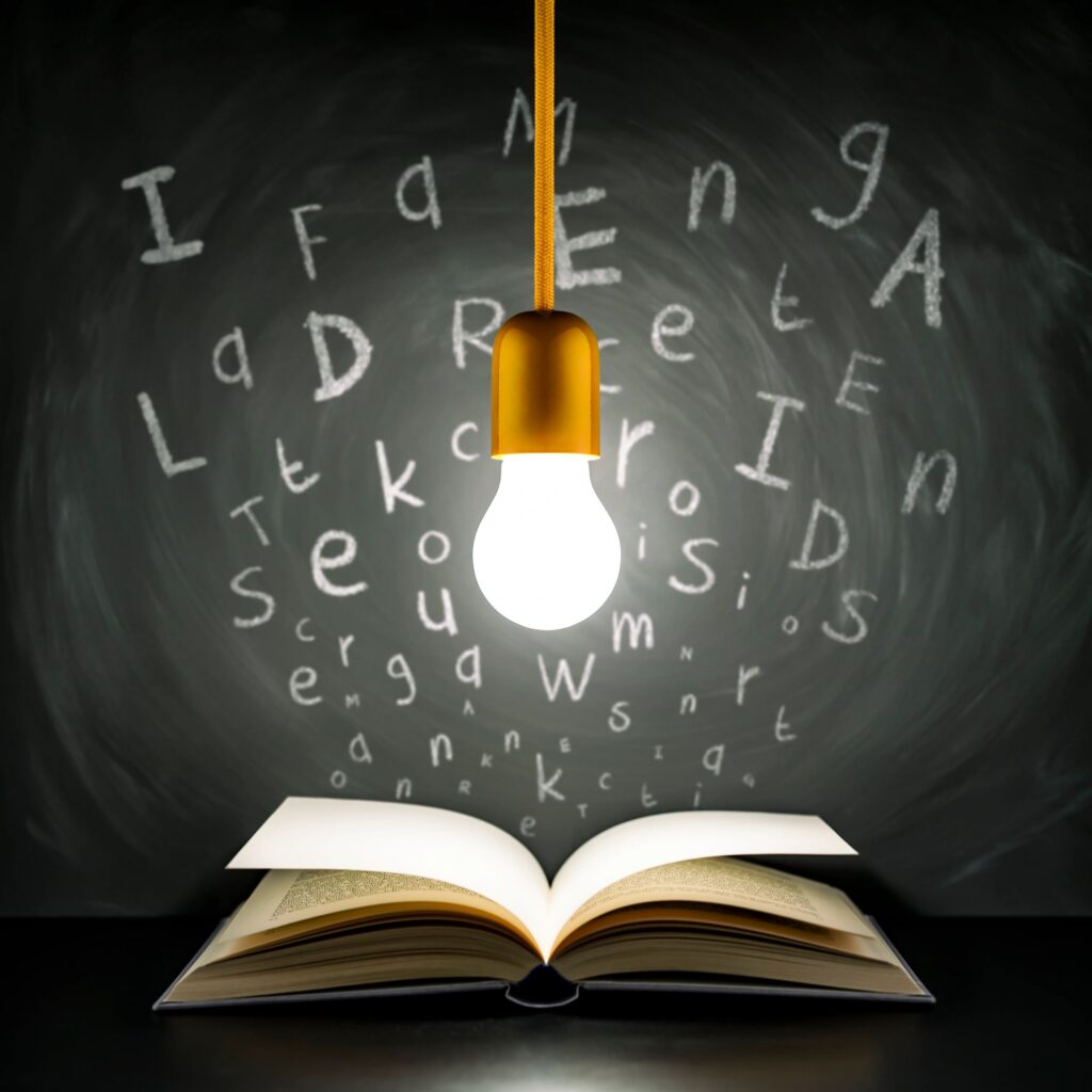 Open academic book on a desk with a study light